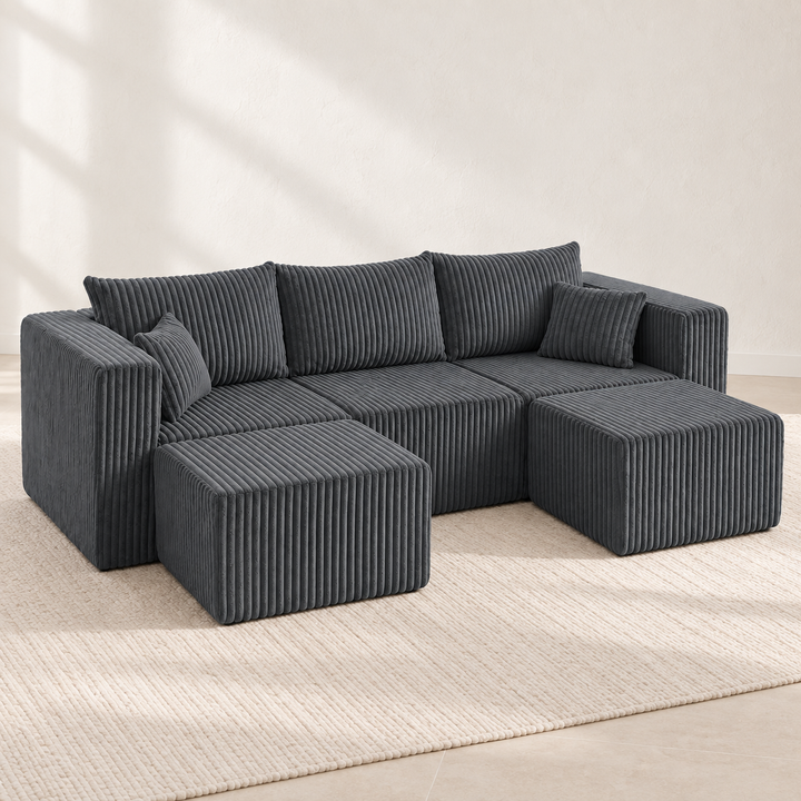 Dark grey three-seat corduroy sectional in a bright Nordic interior
