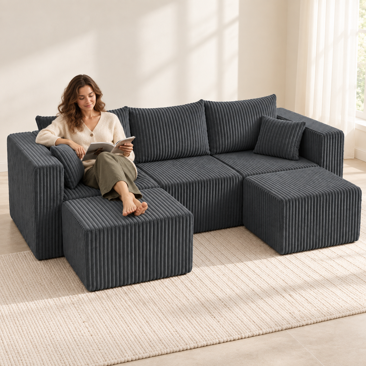 Woman reading on a dark grey three-seat corduroy sectional